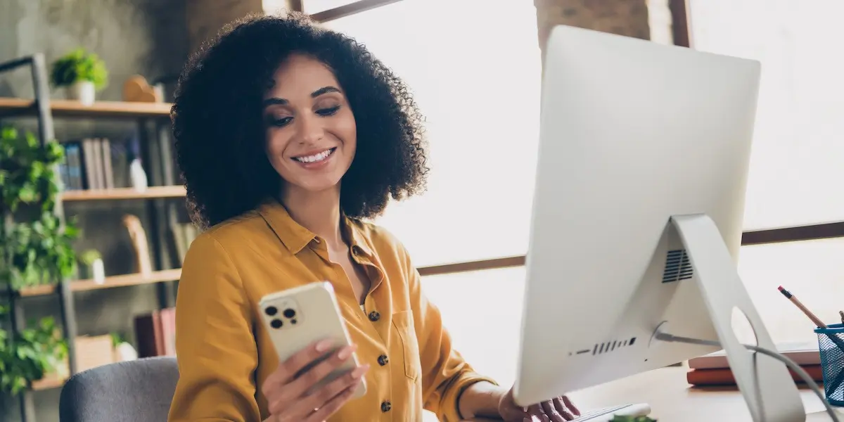 ux reddit A young female aspiring UX designer researches UX bootcamp Reddit advice on her phone and laptop